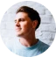 Headshot of Greg looking to the left and smiling